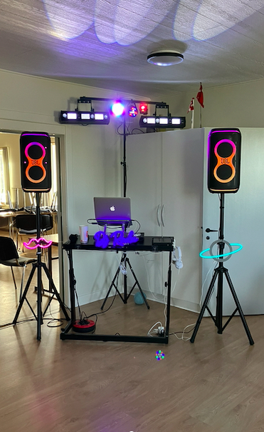 DJ Radus kompakte opsætning med højtalere og neon-detaljer i et lyst rum