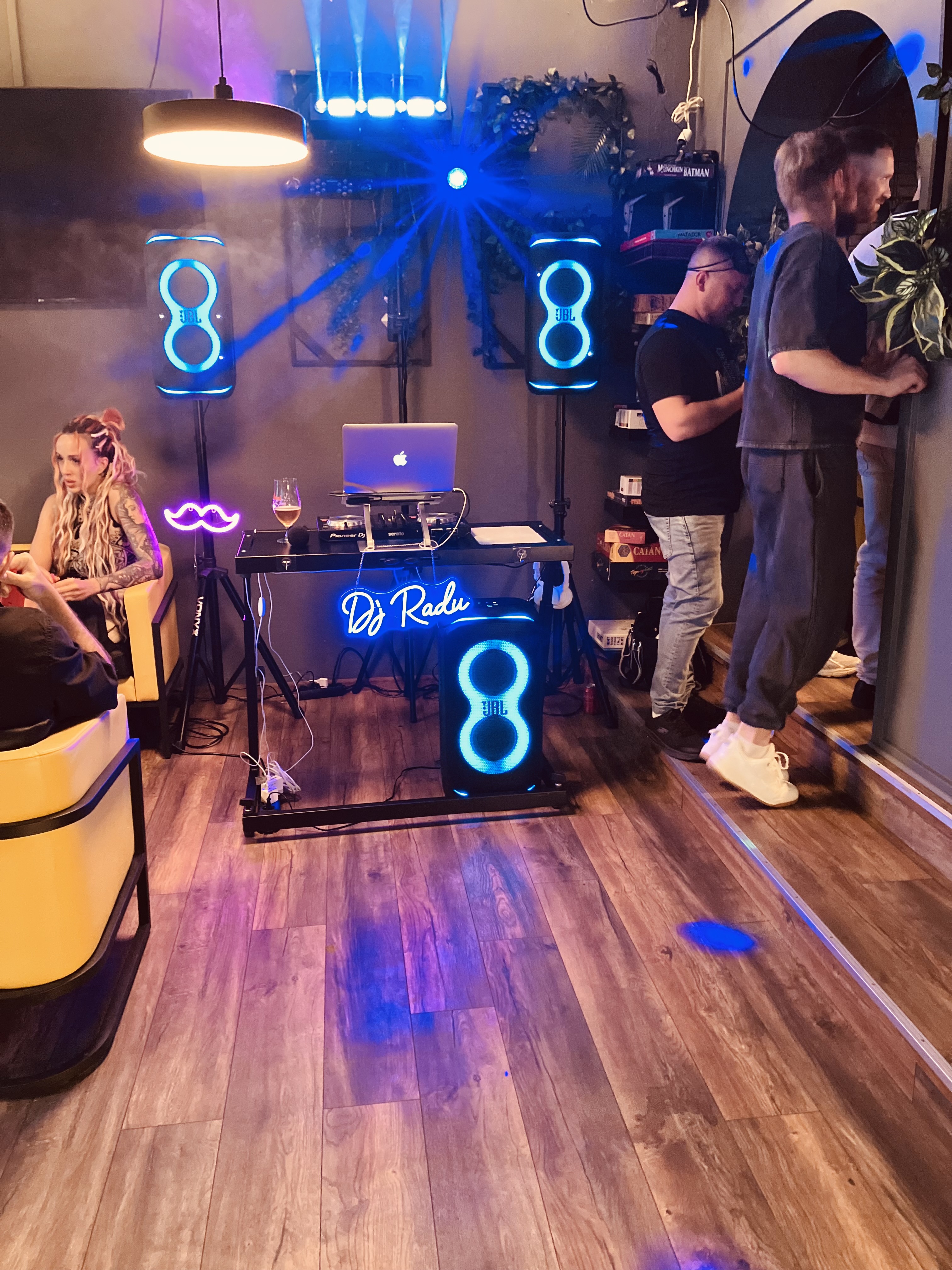 DJ Radu bag pladerne i et lounge-hjørne under neonskiltet 'DJ Radu'