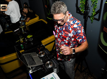 DJ Radu mixer bag pladerne, omgivet af festbelysning