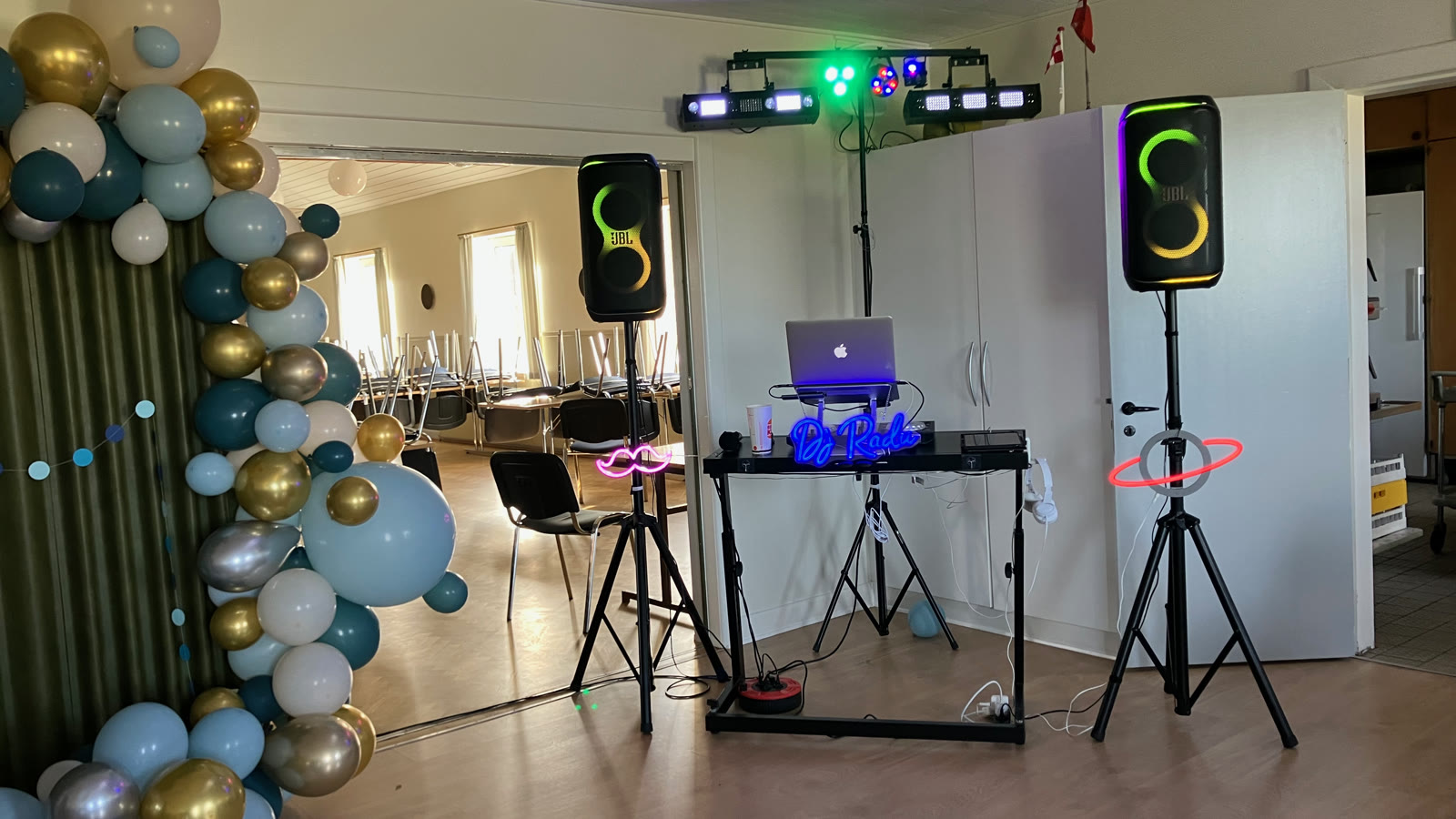 DJ Radu's setup with speakers and lighting bar next to the balloon arch