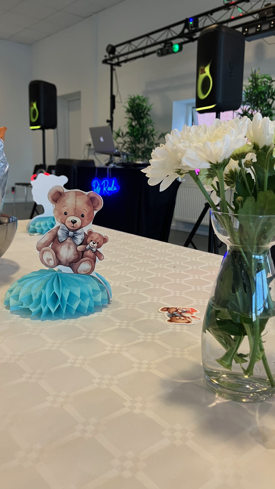 Decorated table with a teddy bear and flowers at the christening party