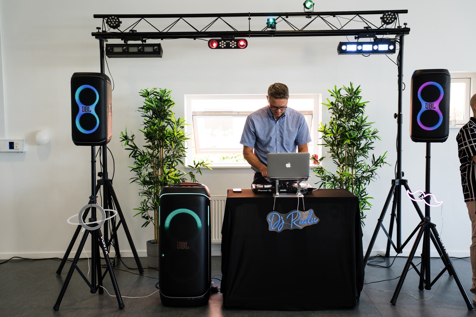 DJ Radu at the decks with the lighting bar and plants around
