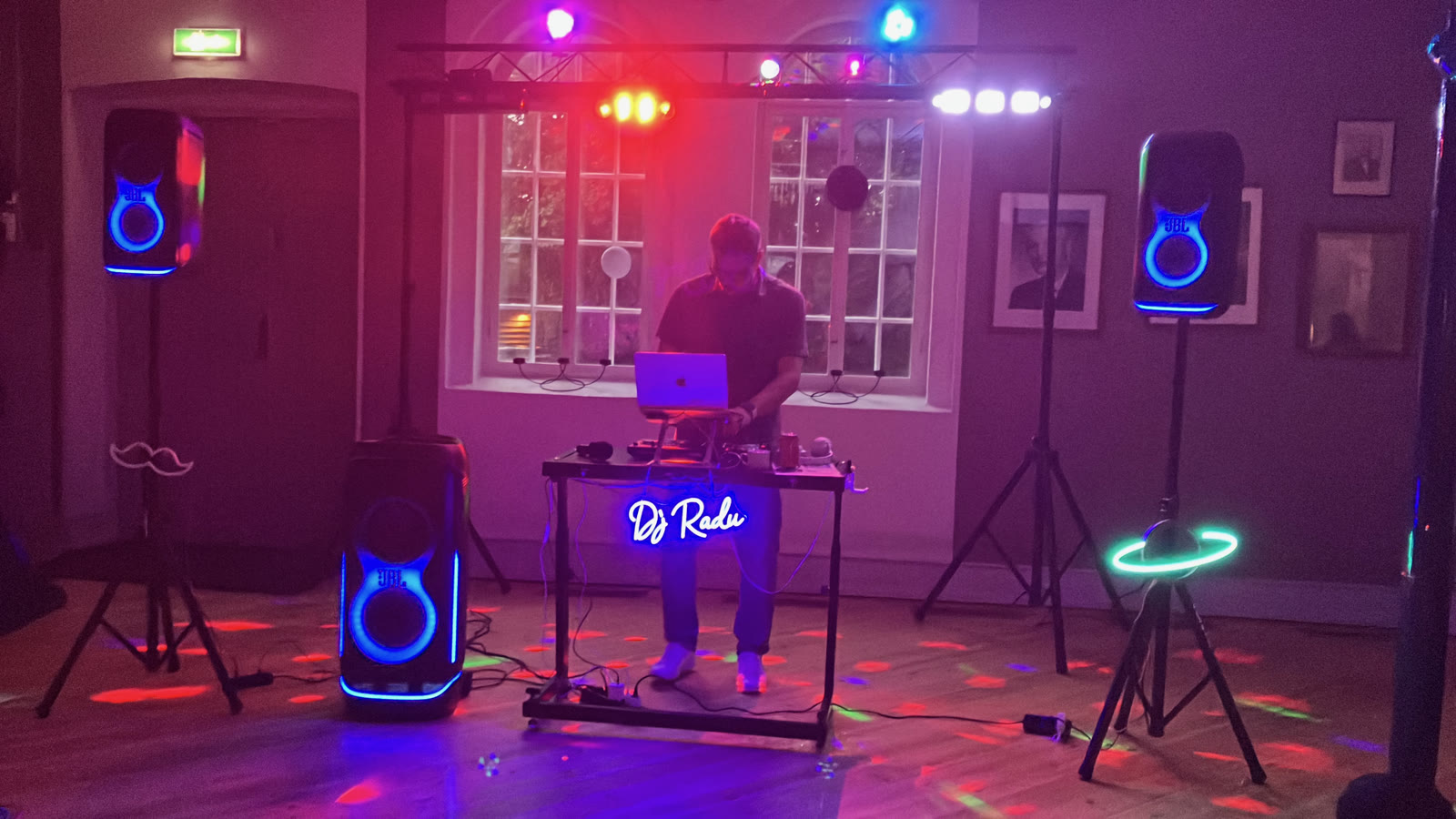 DJ Radu la pupitru, în lumini roșii și albastre, seara
