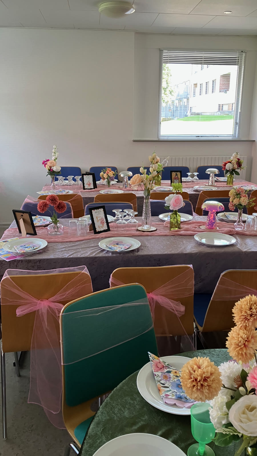 Borde med blomster og lyserøde sløjfer på stolene